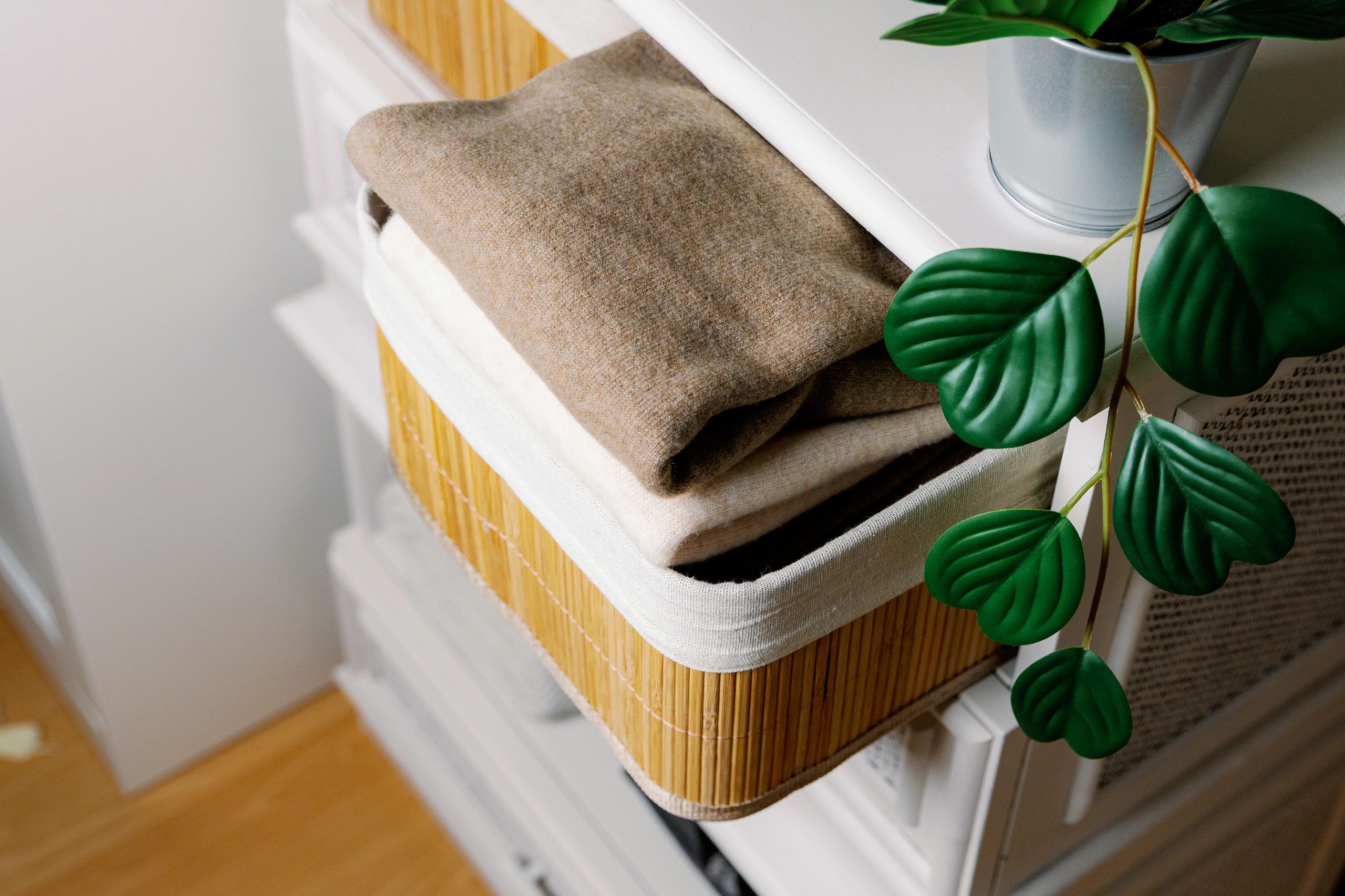 Neatly folded sweaters organized in a closet bin